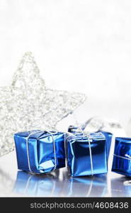 Christmas blue gifts and decoration on shiny silver background