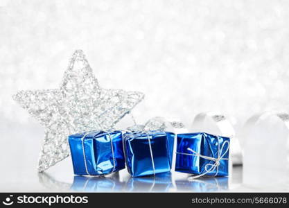 Christmas blue gifts and decoration on shiny silver background