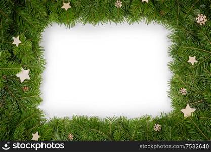 Christmas border arranged with fresh fir branches and wooden decor isolated on white background , copy space for text. Christmas border of fir branches