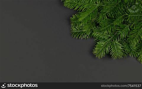 Christmas border arranged with fresh fir branches on black paper background , copy space for text. Christmas border of fir branches