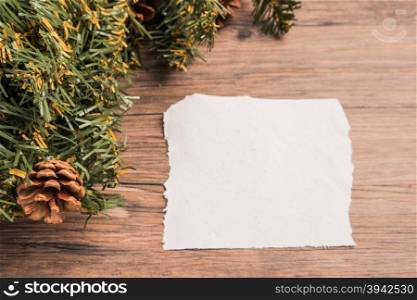 Christmas border design with pine cone and fir branches on parchment paper over old oak wood