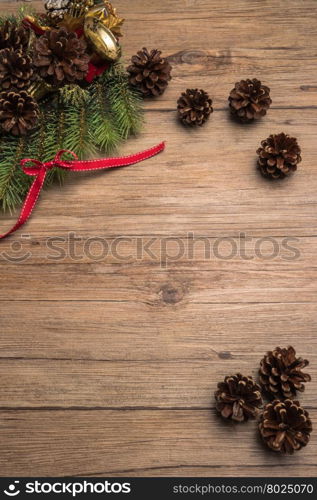 Christmas border design with pine cone, fir branches and ribbon over old oak wood