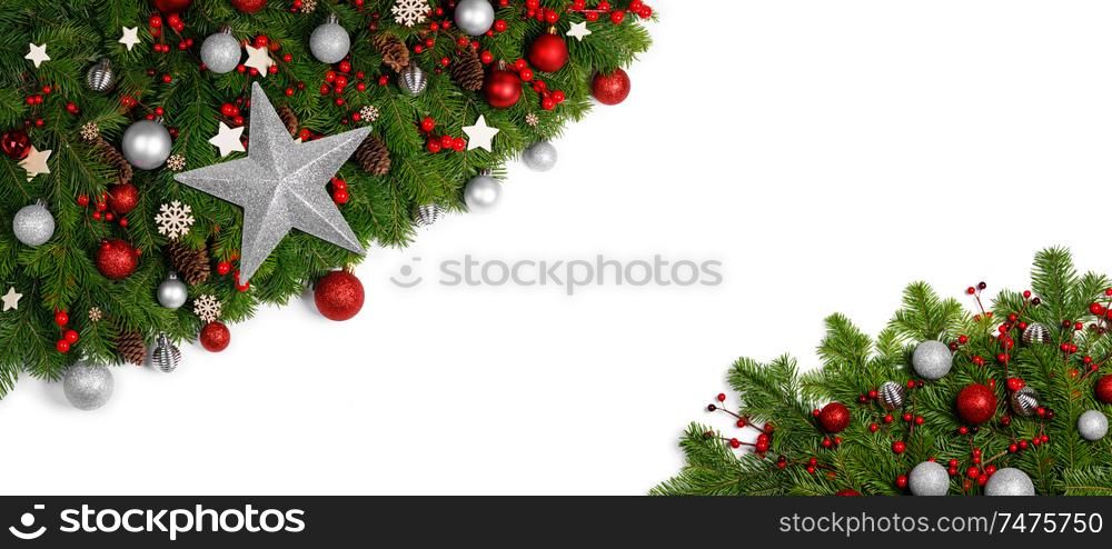 Christmas Border frame of tree branches around white background with copy space isolated, red decor, berries, stars, cones, candy canes. Christmas frame of tree branches