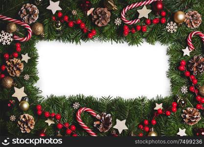 Christmas Border frame of tree branches on white background with copy space isolated, red and white decor, berries, stars, cones. Christmas frame of tree branches