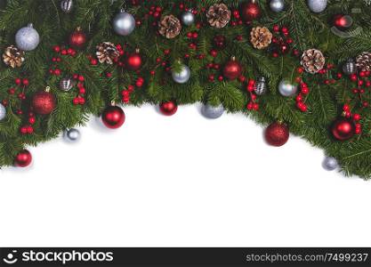 Christmas Border frame of tree branches on white background with copy space isolated, red and silver decor, berries, stars. Christmas frame of tree branches