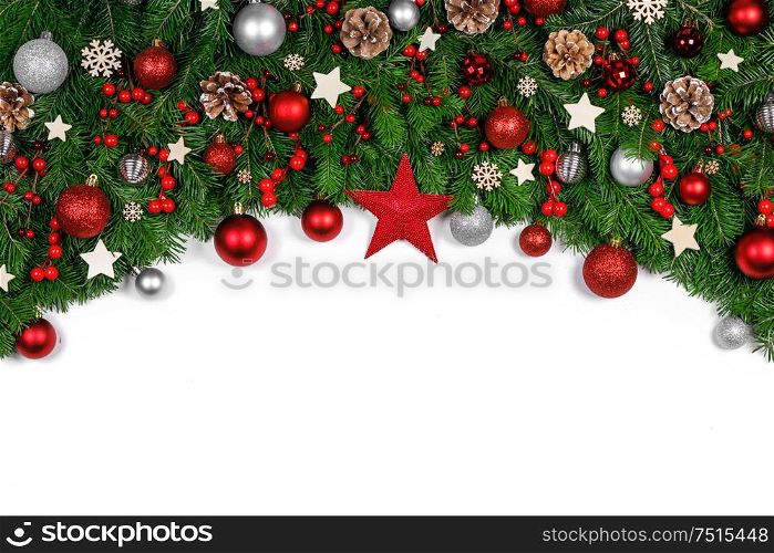 Christmas Border frame of tree branches on white background with copy space isolated, red and golden decor, berries, stars, cones. Christmas frame of tree branches