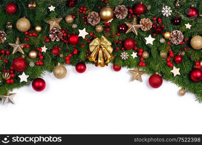 Christmas Border frame of tree branches on white background with copy space isolated, red and golden decor, berries, stars. Christmas frame of tree branches