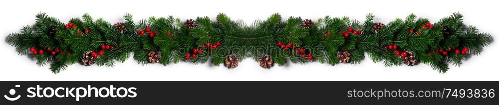 Christmas Border frame of tree branches red berries and pine cones on white background with copy space isolated. Christmas frame of tree branches