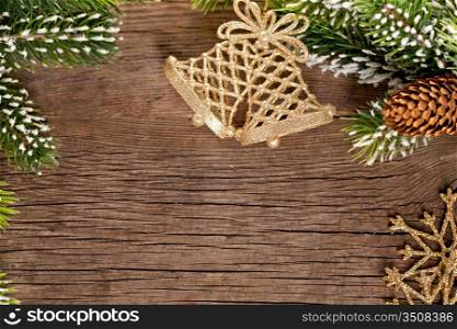 Christmas border from branch and bells on wooden background
