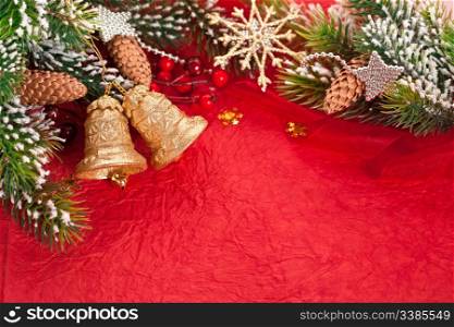Christmas border from branch and decorations on red background