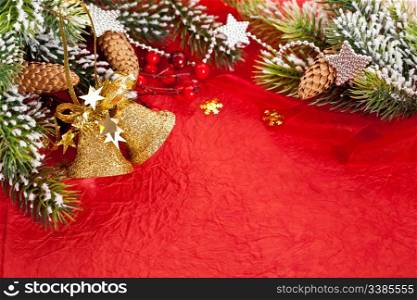 Christmas border from branch and decorations on red paper background
