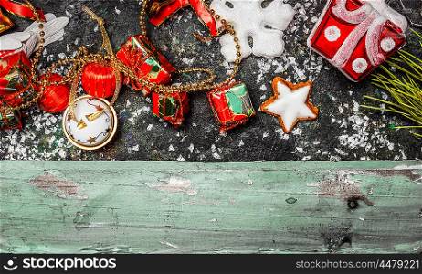 Christmas border with red holiday decorations on rustic wooden background, top view