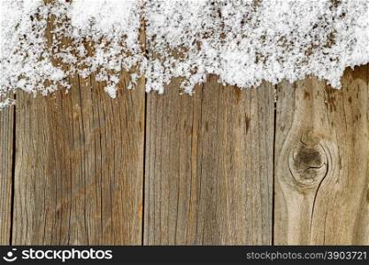 Christmas border with snow on rustic wooden boards.