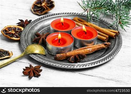 Christmas candle with cinnamon,star anise and fir branch
