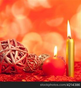 christmas candles with dried baubles on red lights background