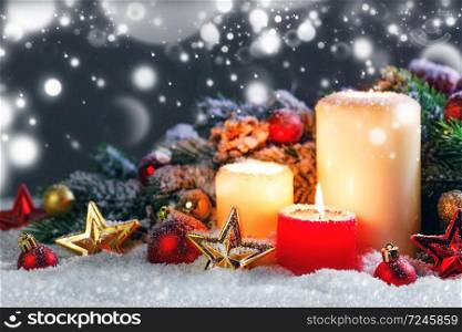 Christmas candles with traditional decorative stars , red baubles , pine cones and green branches on snow. Christmas candles with decoration