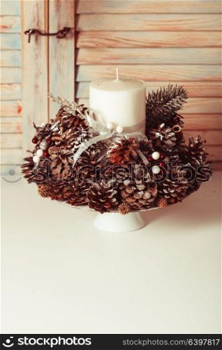 Christmas candlestick on the table, decoration with cones. Christmas cones candlestick