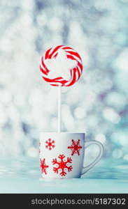 Christmas candy in cup with snowflakes at winter bokeh background, front view