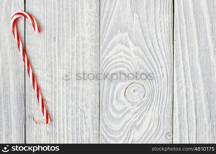 Christmas cane decoration on white wooden background