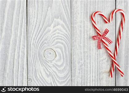 Christmas cane decoration on white wooden background