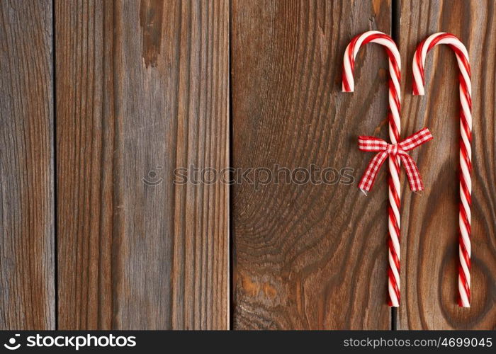 Christmas cane decoration on wooden background