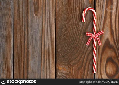 Christmas cane decoration on wooden background