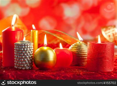 Christmas card candles red and golden in a row on blurred background