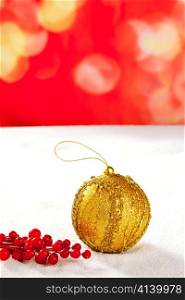 Christmas card of golden bauble berries on snow and red background