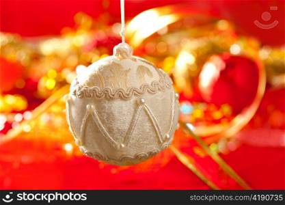 Christmas card of white velvet bauble and red blur background