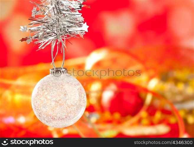 Christmas card tinsel snow crystal bauble on red blurred background