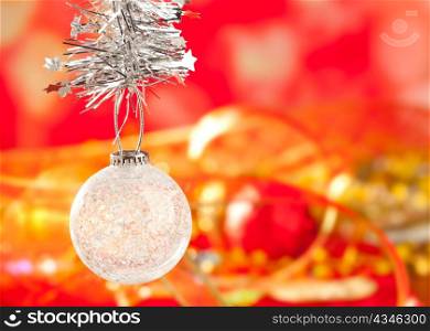 Christmas card tinsel snow crystal bauble on red blurred background