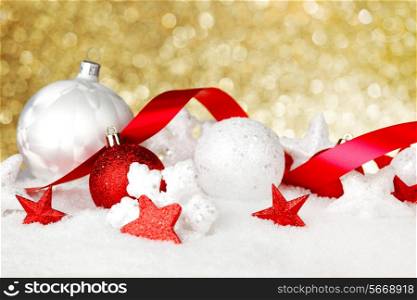 Christmas card with beautiful red and white decorations in snow on golden background