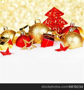 Christmas card with colorful decorations in snow on gold background