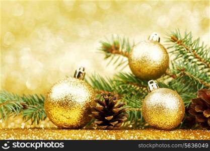 Christmas card with fir branch and decorations on golden gitter background