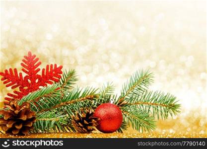 Christmas card with fir branch and decorations on golden gitter background