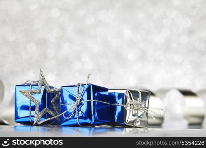 Christmas card with gifts and decoration on shiny silver background