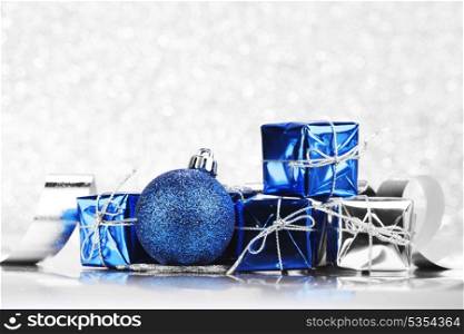 Christmas card with gifts and decoration on shiny silver background