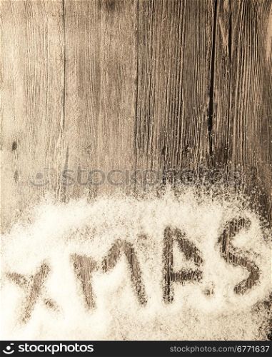 Christmas card with the inscription xmas in the snow on a wooden background. Christmas card with the inscription xmas in the snow on a wooden background.