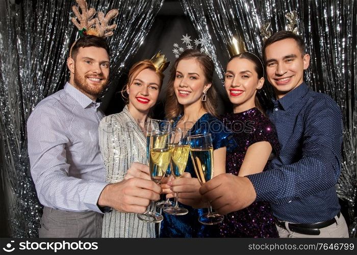 christmas, celebration and holidays concept - happy friends clinking champagne glasses at party. friends with champagne glasses at christmas party