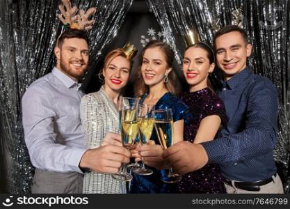 christmas, celebration and holidays concept - happy friends clinking champagne glasses at party. friends with champagne glasses at christmas party