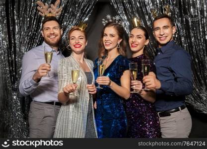 christmas, celebration and holidays concept - happy friends toasting champagne glasses at party. friends with champagne glasses at christmas party
