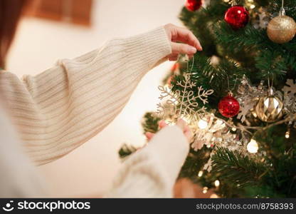 Christmas celebration concept, Young asian woman decorating christmas tree in living room at home.
