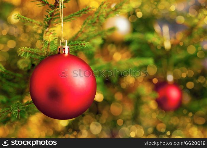 Christmas celebration holiday background - christmas-tree decoration bauble on decorated Christmas tree with defocused blurred lights bokeh and copyspalce. Christmas-tree decoration bauble on decorated Christmas tree bac