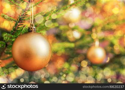Christmas celebration holiday background - christmas-tree decoration bauble on decorated Christmas tree with defocused blurred lights bokeh and copyspalce. Christmas-tree decoration bauble on decorated Christmas tree bac
