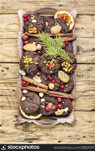 Christmas chocolate cookies with nuts and pistachios on wooden table. Festive chocolate cookie
