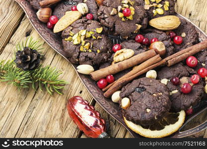 Christmas chocolate cookies with nuts and pistachios on wooden table. Tasty homemade Christmas cookies