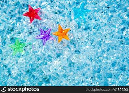 christmas colorful glass stars on cold blue ice