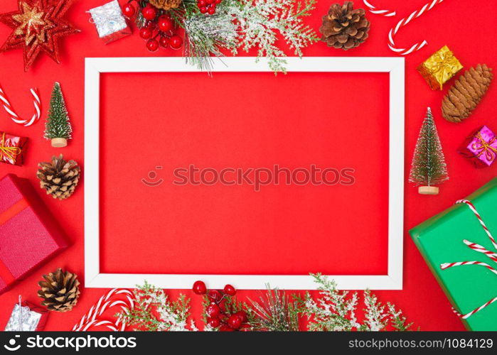 Christmas composition decorations, fir tree branches with Photo square frame on red background. Merry Christmas concept. Copy space for text