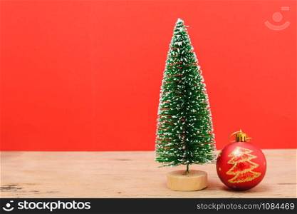 Christmas composition decorations, minimal green fir tree branches with snow and ball on red background. Merry Christmas concept. Copy space for text