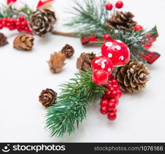 Christmas composition. Fir tree branches, red decorations on white background.
